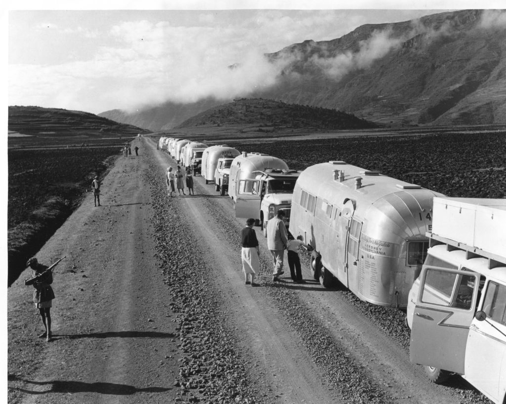 This photo was taken on the road in Africa but the location is unknown. To protect themselves from lions and tigers, the men in the lower left are carrying rifles. 