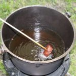 A morsel of steak is dipped into hot oil fondue over Eccozoom stove inside Quick-Set Escape Shelter by Clam.