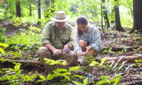 Father and daughter using a knife sharpener in the wilderness